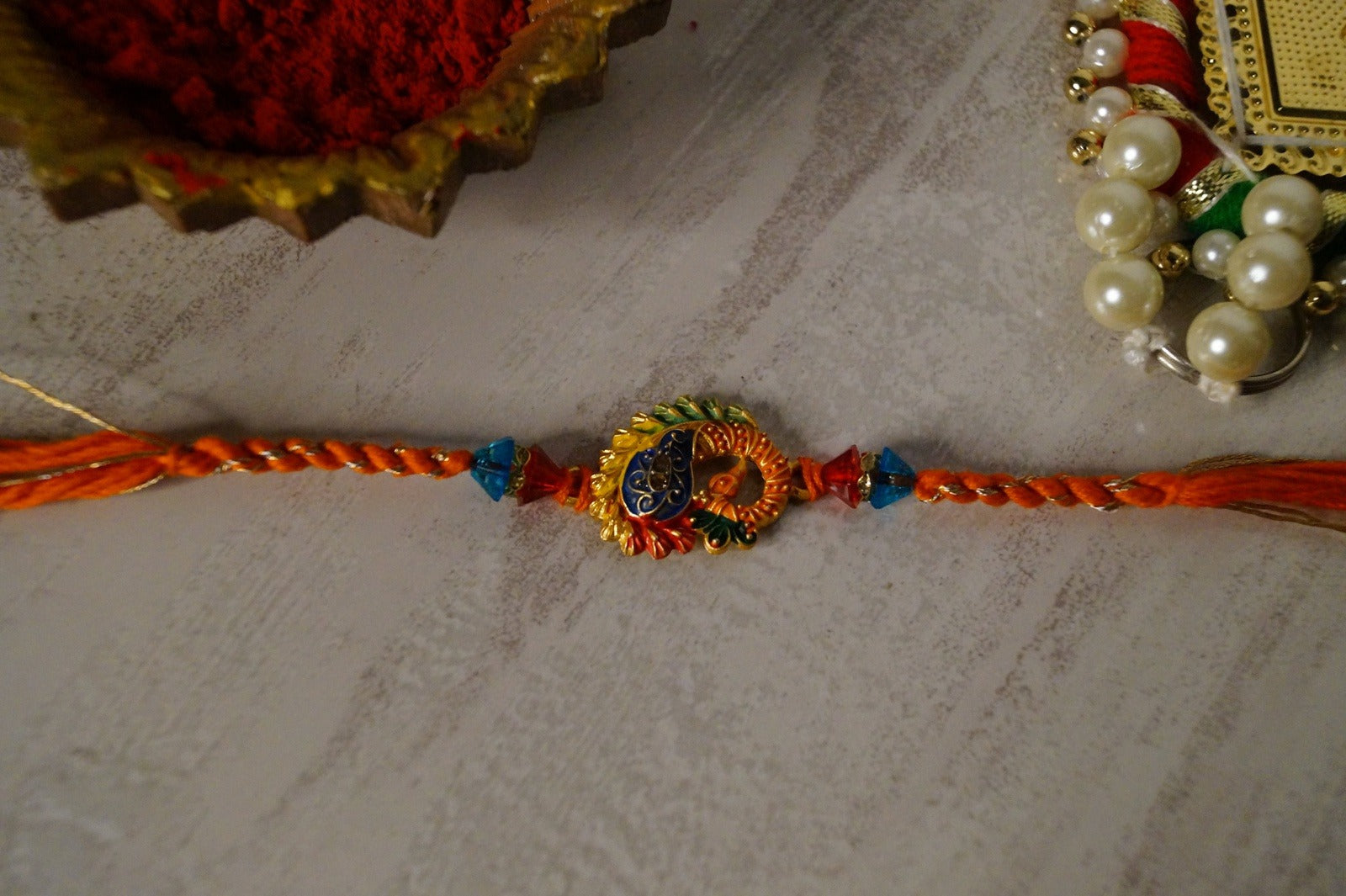 Peaccock Colorful Stone and Gold Brass Thread Rakhi at Kamakhyaa by Kamakhyaa. This item is Multicolor, Natural, Rakhi, Under 1500, Under 1750, Upcycled