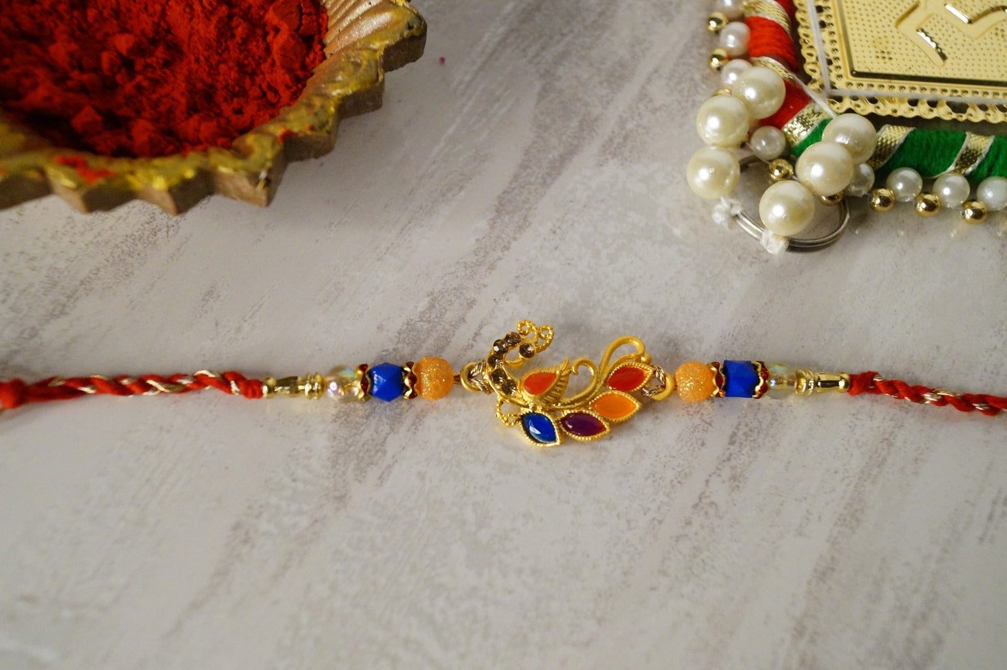 Peacock Stone and Colorful Stone Thread Rakhi at Kamakhyaa by Kamakhyaa. This item is jewelry, Multicolor, Natural, Rakhi, Under 1500, Under 1750, Upcycled