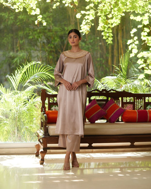 Beige Satin Silk Kurta Pant Set at Kamakhyaa by Mayura Kumar. This item is Beige, Casual Wear, Festive Wear, Kurta Pant Sets, Mayura Kumar, Regular Fit, Satin, Silk, Solids, Timeless Elegance, Womenswear