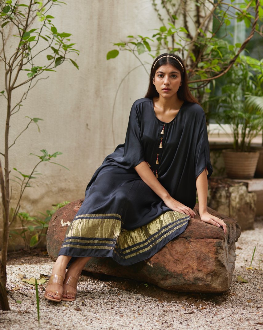 Black Silk Kaftan With Golden Border at Kamakhyaa by Mayura Kumar. This item is Ajrakh Heritage, Black, Casual Wear, Dresses, Festive Wear, Kaftans, Mayura Kumar, Modal Silk, Relaxed Fit, Solids, Womenswear