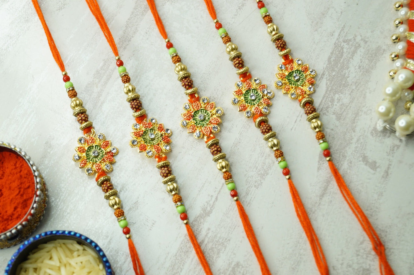 Set of 5-Floral Rudraksh Thread Rakhi at Kamakhyaa by Kamakhyaa. This item is jewelry, Natural, Rakhi, Red, Upcycled