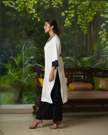 White And Black Satin Silk Kurta Pant Set at Kamakhyaa by Mayura Kumar. This item is Black, Casual Wear, Festive Wear, Kurta Pant Sets, Mayura Kumar, Regular Fit, Satin, Silk, Solids, Timeless Elegance, White, Womenswear