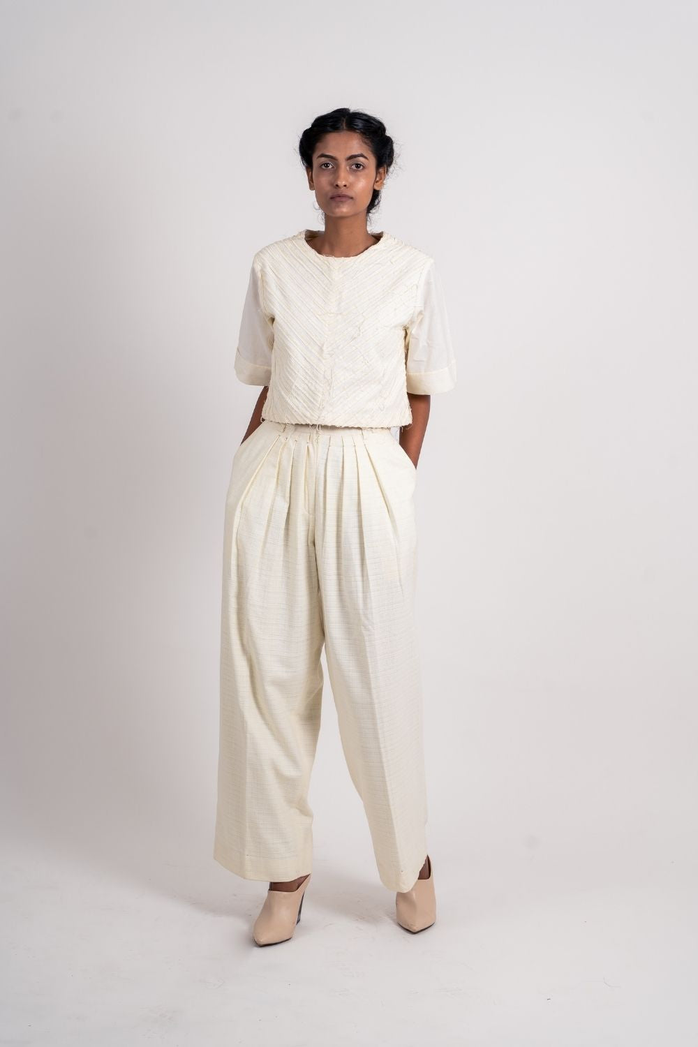White Pleated Pants at Kamakhyaa by Ahmev. This item is Bottoms, Casual Wear, Fitted At Waist, Handloom Cotton, July Sale, July Sale 2023, Natural, Palazzo Pants, Textured, White, Womenswear