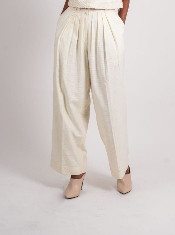 White Pleated Pants at Kamakhyaa by Ahmev. This item is Bottoms, Casual Wear, Fitted At Waist, Handloom Cotton, July Sale, July Sale 2023, Natural, Palazzo Pants, Textured, White, Womenswear