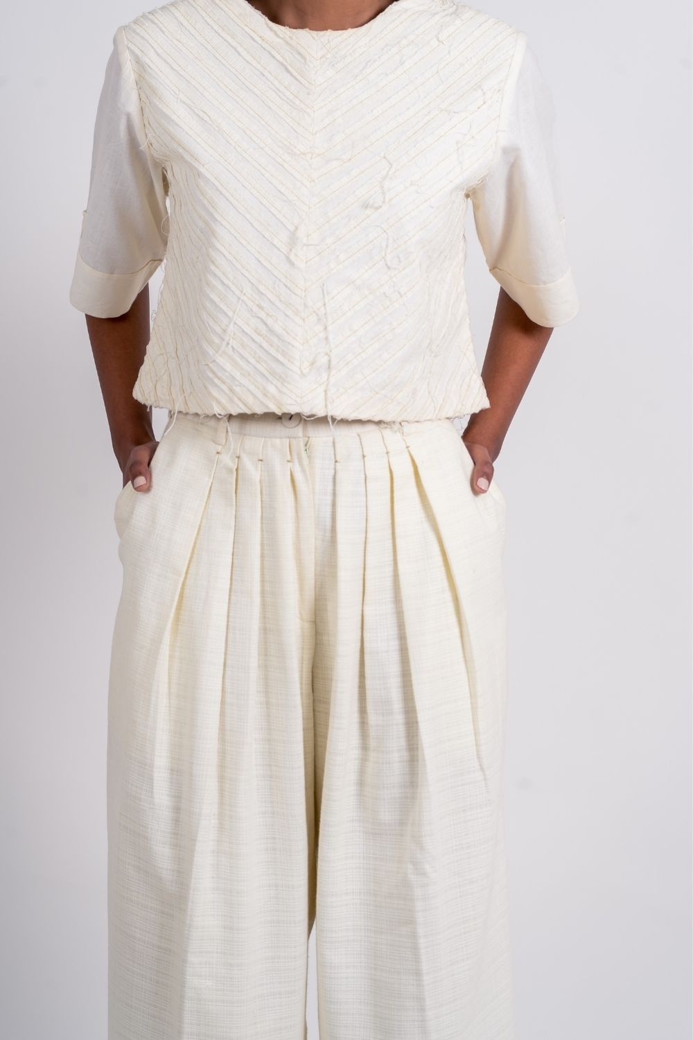 White Pleated Pants at Kamakhyaa by Ahmev. This item is Bottoms, Casual Wear, Fitted At Waist, Handloom Cotton, July Sale, July Sale 2023, Natural, Palazzo Pants, Textured, White, Womenswear