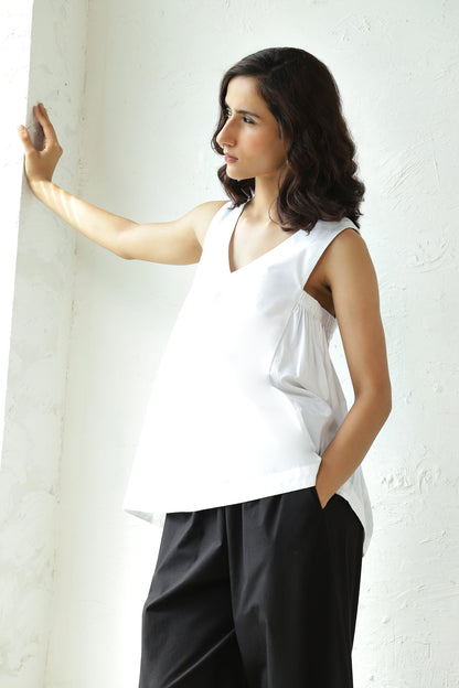 White Sleeveless V Neck Top With Black Flared Pant Set at Kamakhyaa by Canoopi. This item is Black, Canoopi, Casual Wear, Complete Sets, Natural, Poplin, Regular Fit, Solids, Vacation Co-ords, White, Womenswear